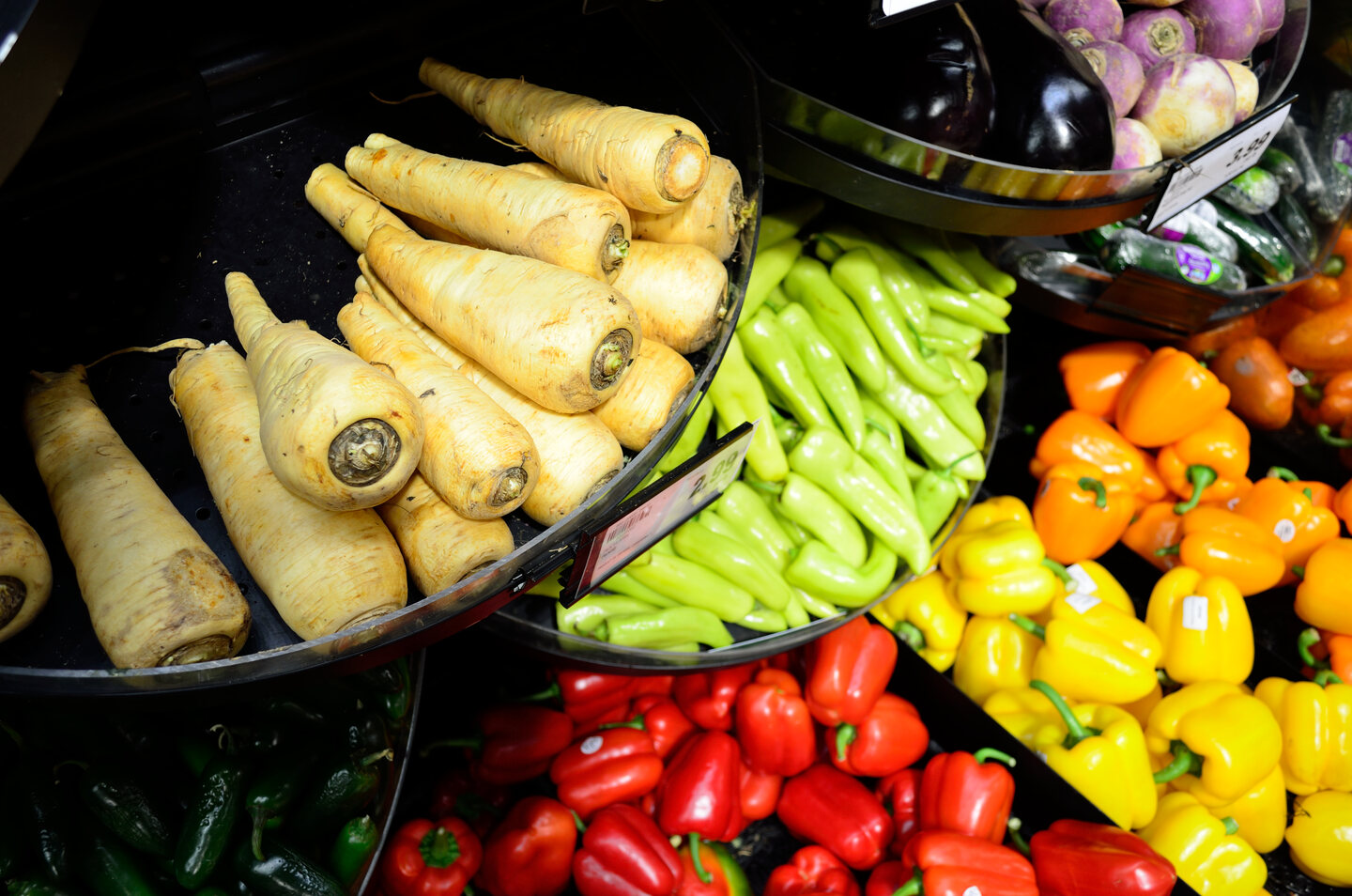 Parsnips, eggplants and capsicums on supermarket shelves